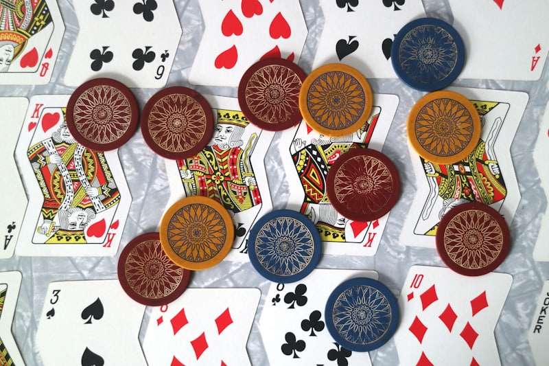 Susunan kartu remi dan tumpukan chip kasino di atas meja hijau sebagai ilustrasi pengelolaan bankroll bermain
