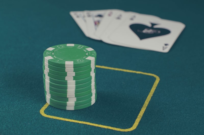 Kartu poker dan tumpukan chip di atas meja felt hijau siap dimainkan